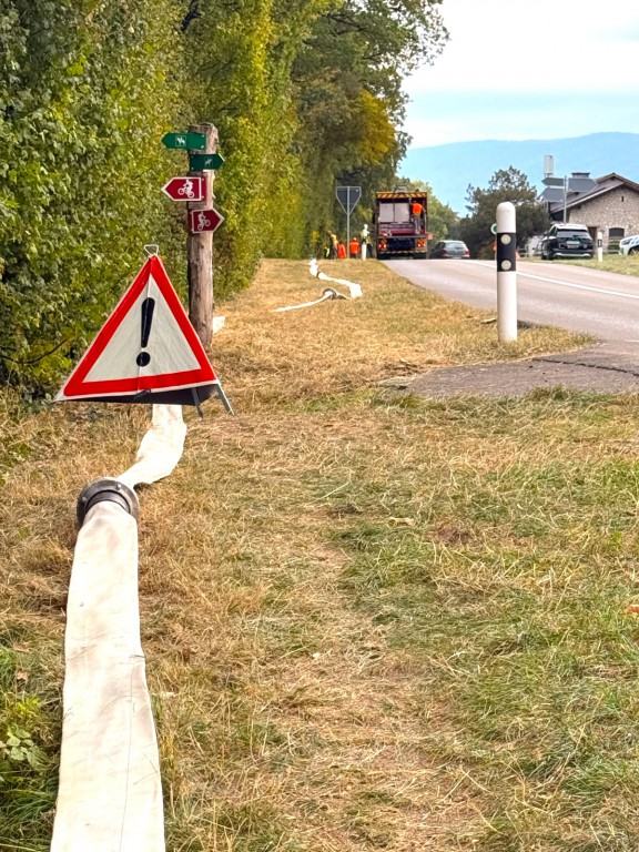 Photo du déploiement de l a conduite de secours, en bordure de route sur la route de la Cézille